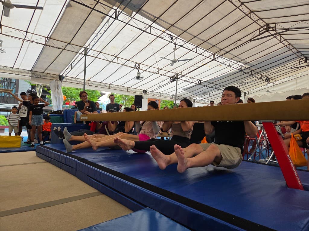 Adults taking on a carnival balance beam challenge