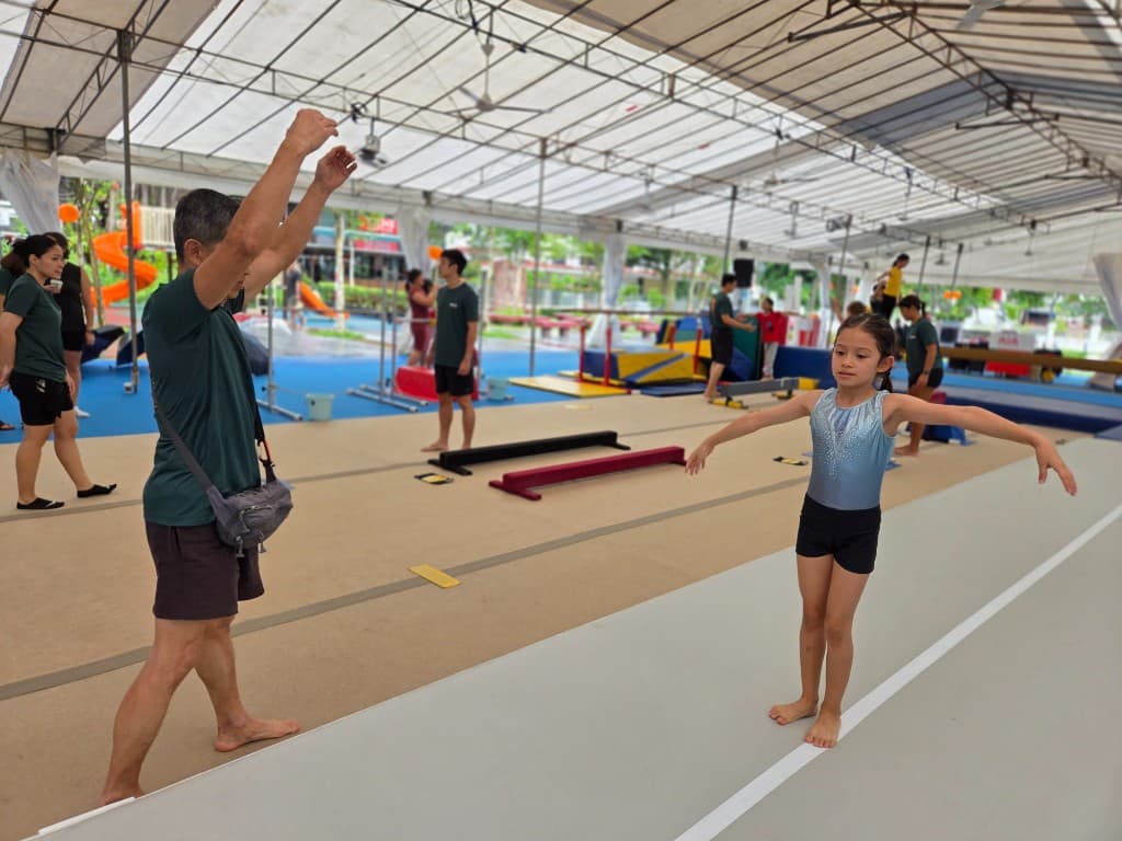 Young gymnast practising balance with a coach