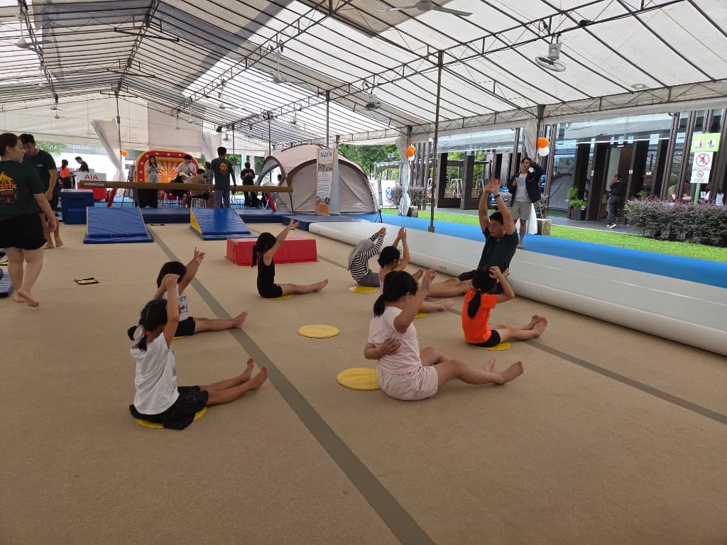 Children stretching together during a BazGym carnival class
