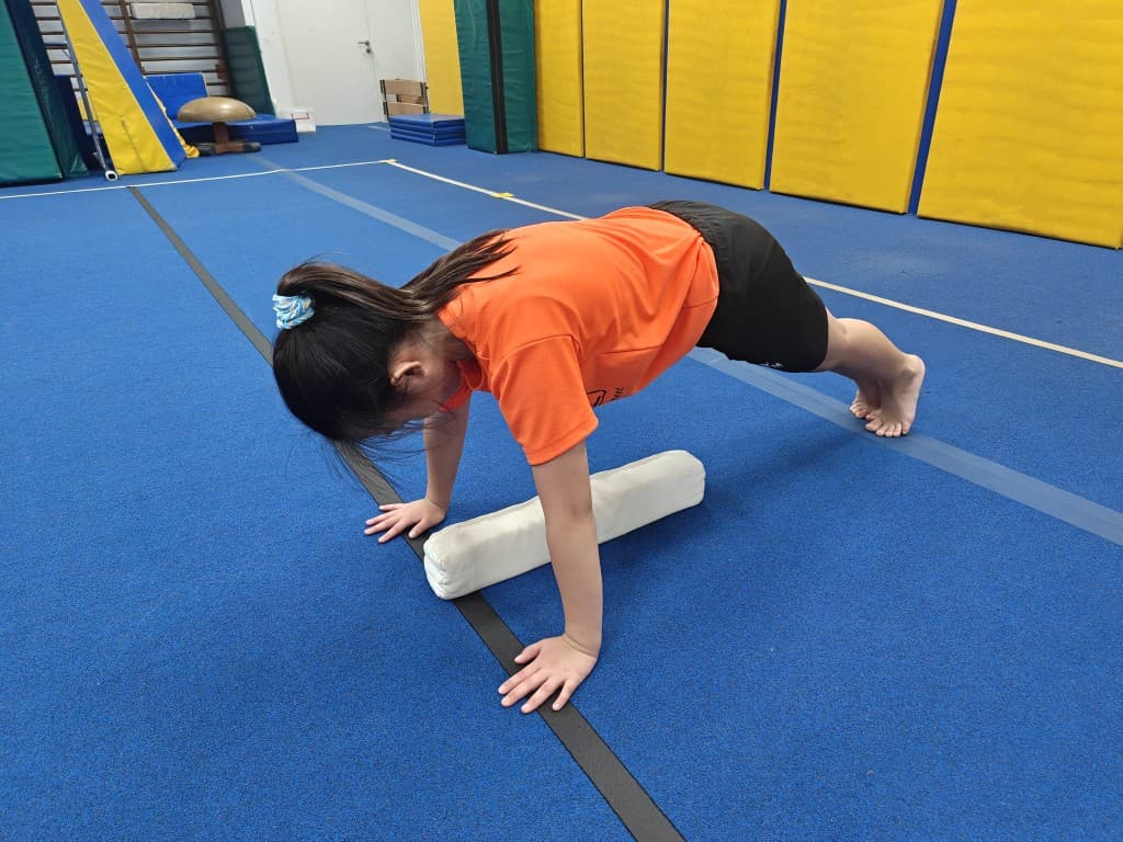 Young gymnast doing a push-up for the BazGym strength challenge