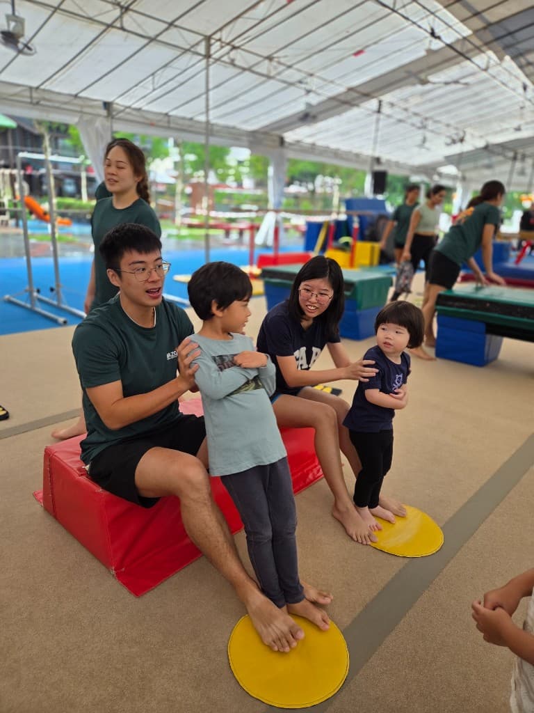 Coaches guiding toddlers through a pop-up gymnastics class